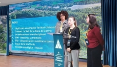 Tres noies joves estudiants presenten un treball amb una projecció al darrere