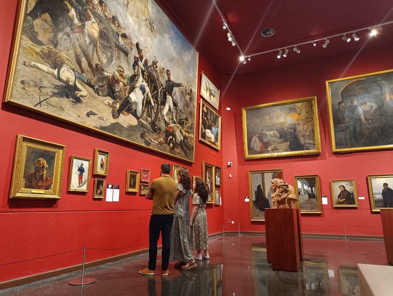 Persones mirant uns quadres a un museu d'art