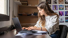 Noia amb un ordinador portàtil a Vila Universitària