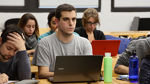 Alumne a l'aula amb un ordinador