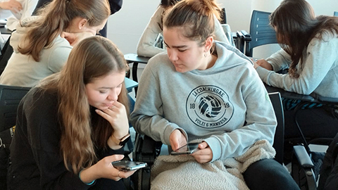 Estudiants realitzant un exercici amb el mòbil