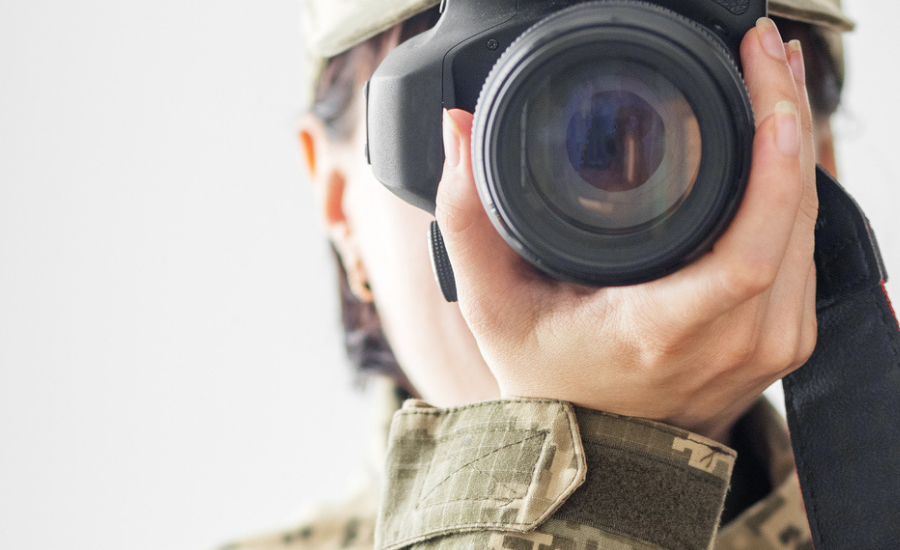 Cara d'una reportera de guerra amb la càmara de fotos.