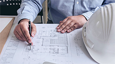 Un professional revisant un plànol d'un edifici