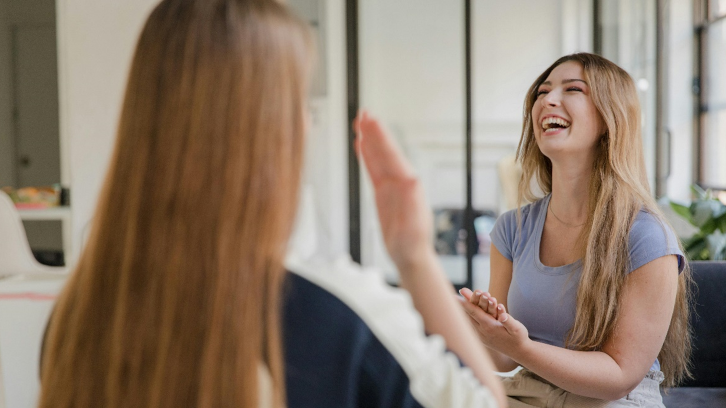 Two Young Women Making Conversation on Hands Gestures